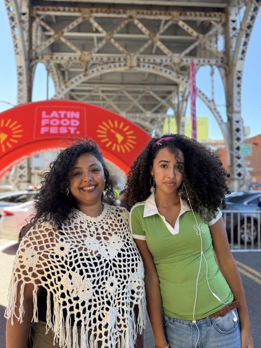 Two friends in front of the Latin Food Fest arch