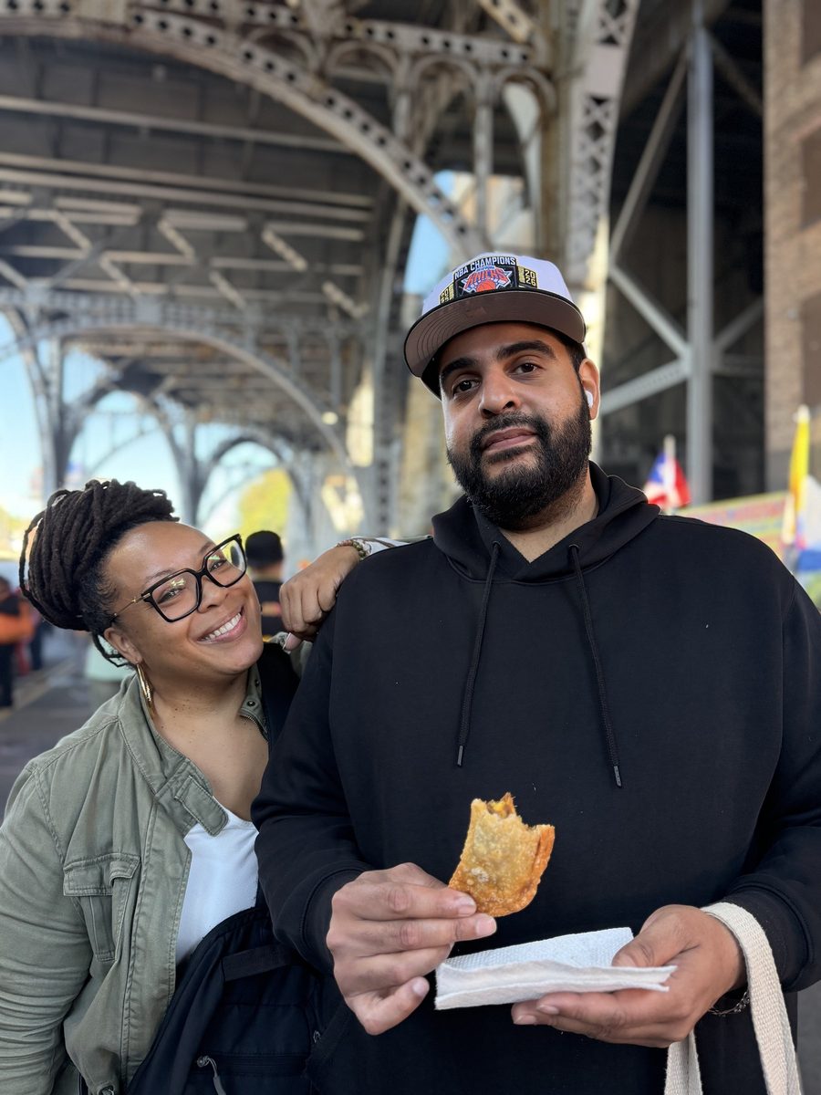 A couple holding an empanada under the arches