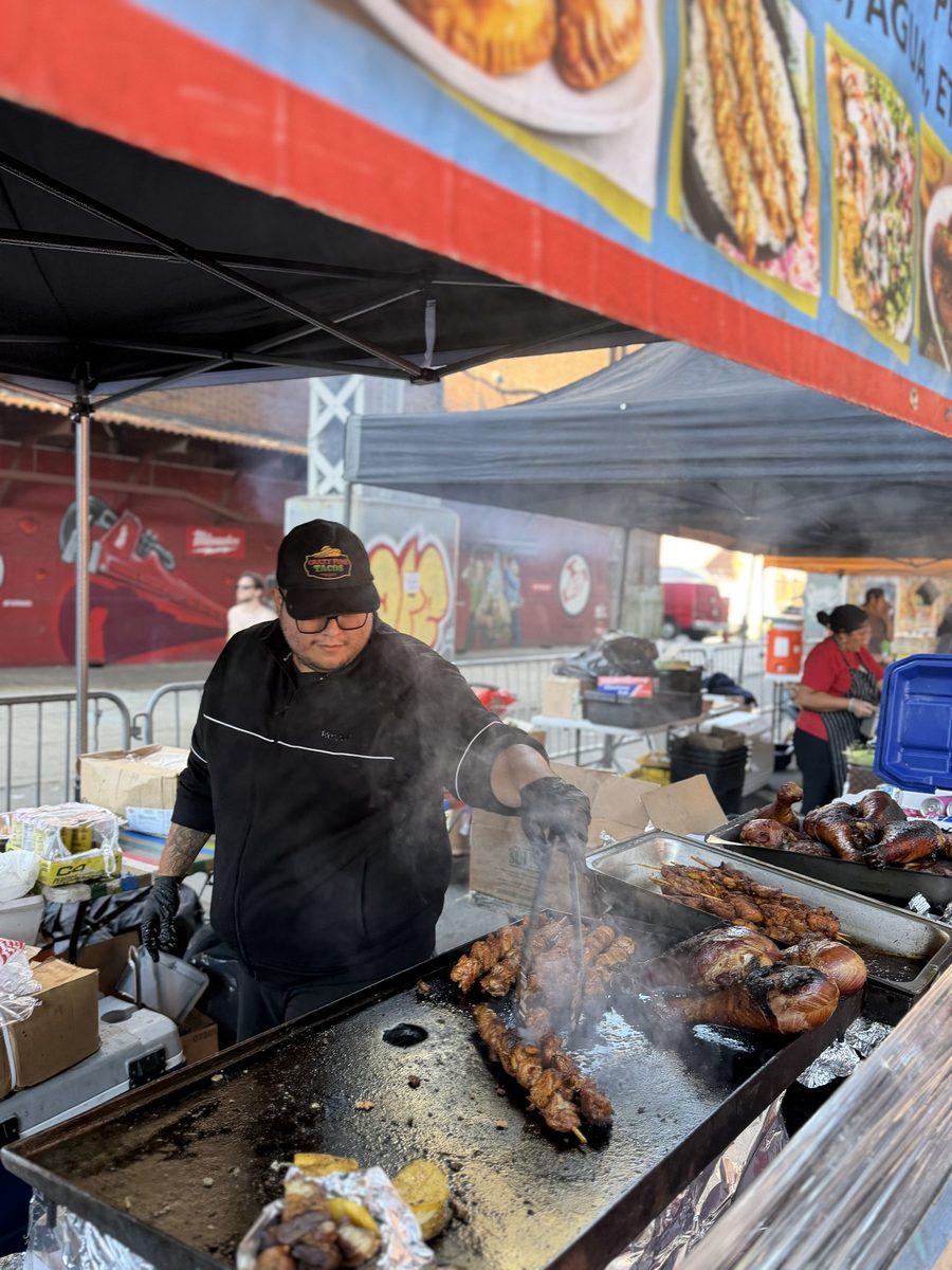 Smoke rising off a flat-top grill at a vendor tent