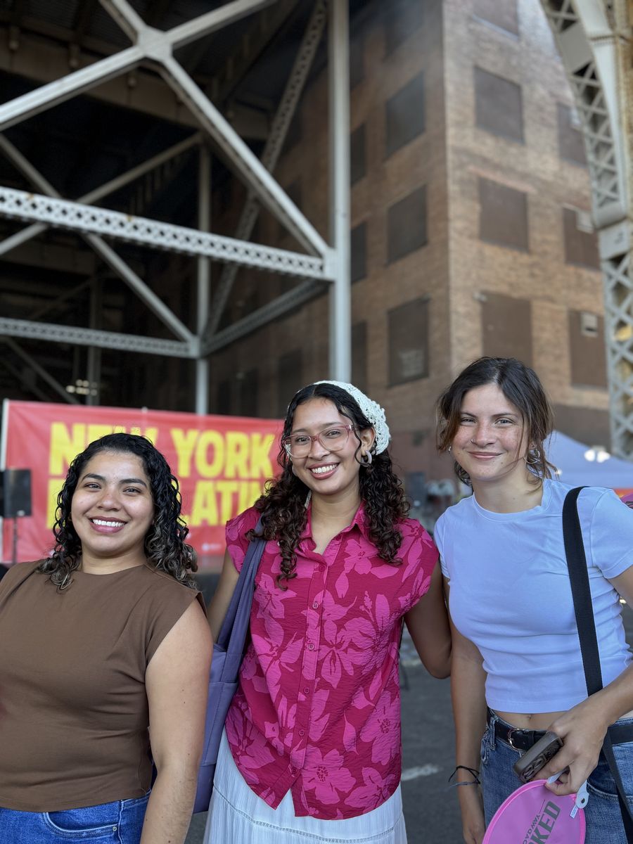 Three friends in front of the New York Eats Latin banner