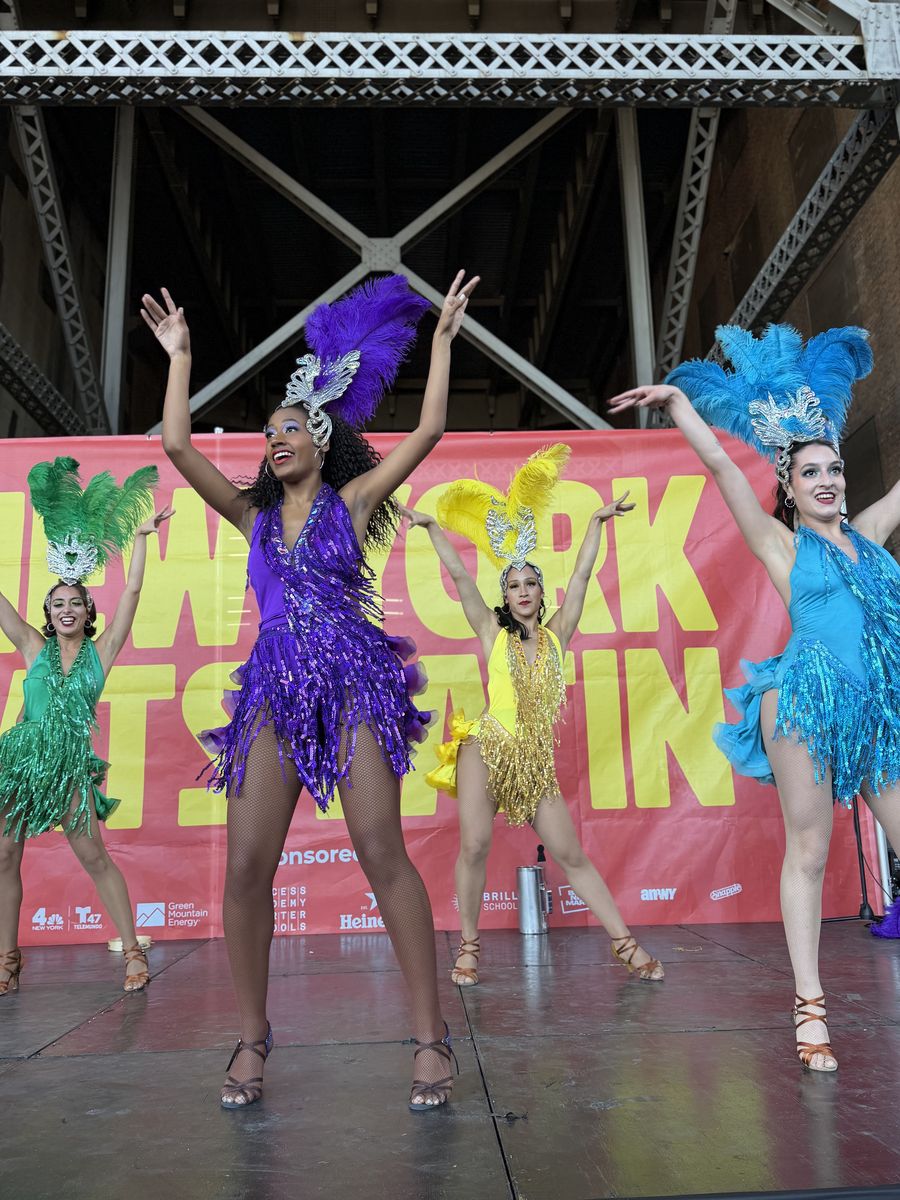 Samba dancers in purple, blue, yellow and green feathers on the Cultural Stage